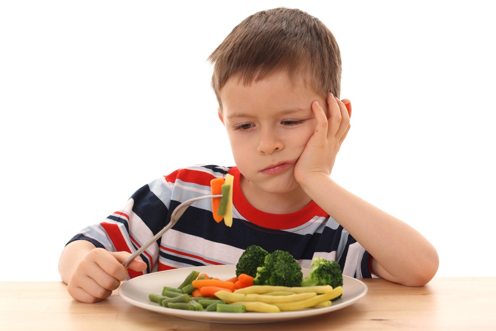 Boy sulking over vegetables